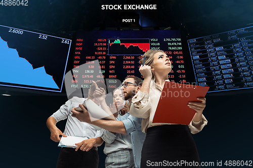 Image of Nervous tensioned investors analyzing crisis stock market with charts on screen on background, falling stock exchange