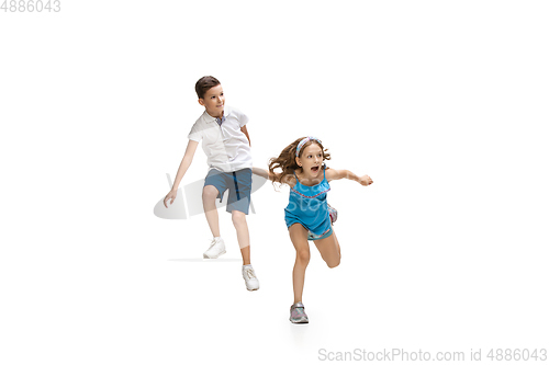 Image of Happy little caucasian girl and boy jumping and running isolated on white background