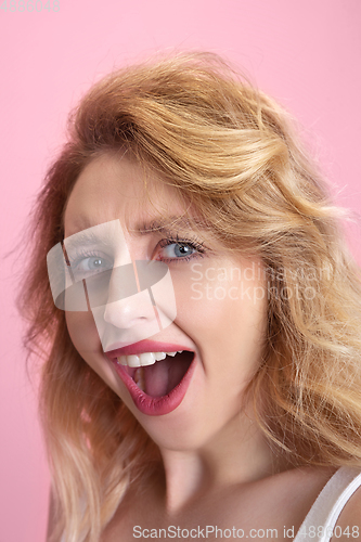 Image of Caucasian young woman\'s portrait isolated on pink studio background. Beautiful female model. Concept of human emotions, facial expression, sales, ad, youth culture.