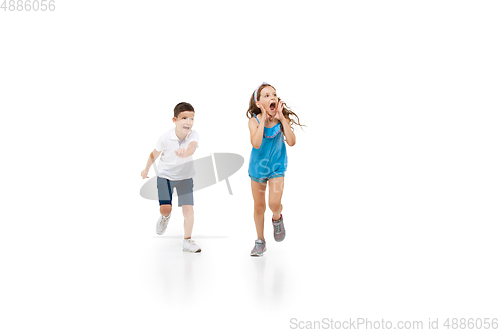 Image of Happy little caucasian girl and boy jumping and running isolated on white background