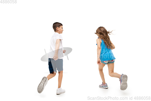 Image of Happy little caucasian girl and boy jumping and running isolated on white background