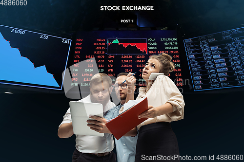 Image of Nervous tensioned investors analyzing crisis stock market with charts on screen on background, falling stock exchange
