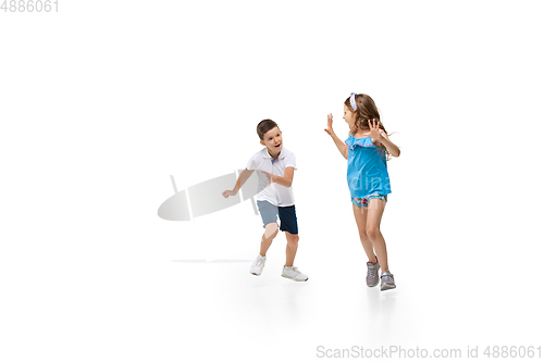 Image of Happy little caucasian girl and boy jumping and running isolated on white background