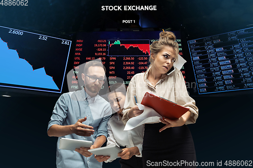 Image of Nervous tensioned investors analyzing crisis stock market with charts on screen on background, falling stock exchange