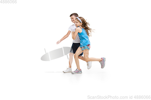 Image of Happy little caucasian girl and boy jumping and running isolated on white background