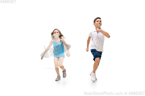 Image of Happy little caucasian girl and boy jumping and running isolated on white background