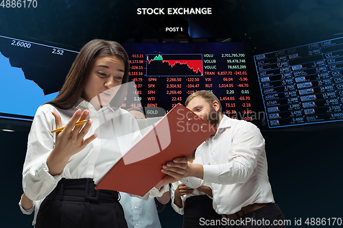 Image of Nervous tensioned investors analyzing crisis stock market with charts on screen on background, falling stock exchange