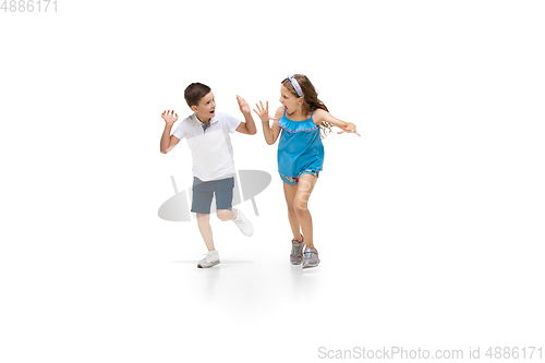 Image of Happy little caucasian girl and boy jumping and running isolated on white background