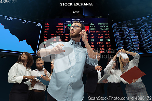 Image of Nervous tensioned investors analyzing crisis stock market with charts on screen on background, falling stock exchange