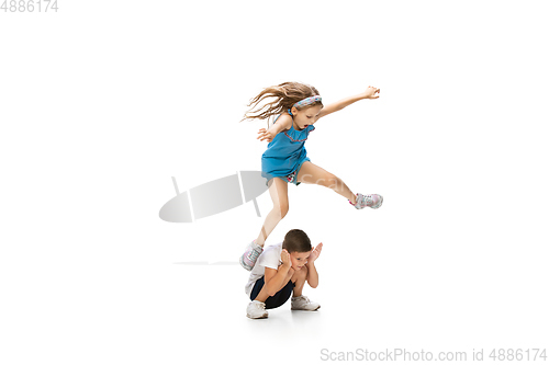 Image of Happy little caucasian girl and boy jumping and running isolated on white background