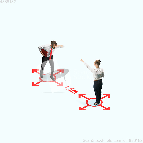 Image of Studio shot of people demonstrating social distancing with arrows indicating the separation.