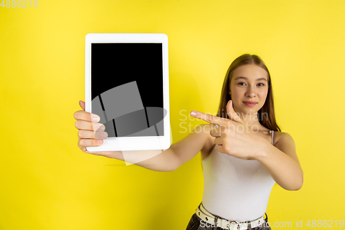 Image of Caucasian young girl\'s portrait isolated on yellow studio background. Beautiful female model. Concept of human emotions, facial expression, sales, ad, youth culture.