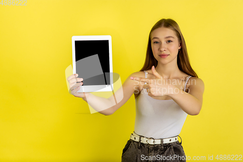 Image of Caucasian young girl\'s portrait isolated on yellow studio background. Beautiful female model. Concept of human emotions, facial expression, sales, ad, youth culture.