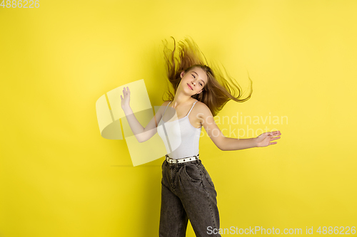 Image of Caucasian young girl\'s portrait isolated on yellow studio background. Beautiful female model. Concept of human emotions, facial expression, sales, ad, youth culture.