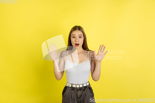 Image of Caucasian young girl\'s portrait isolated on yellow studio background. Beautiful female model. Concept of human emotions, facial expression, sales, ad, youth culture.