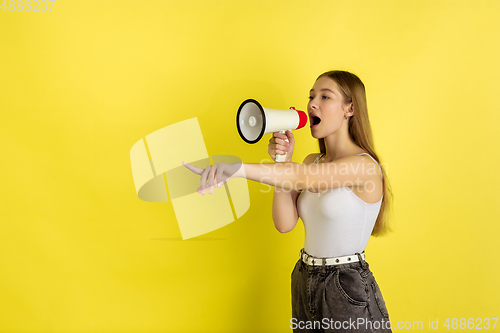 Image of Caucasian young girl\'s portrait isolated on yellow studio background. Beautiful female model. Concept of human emotions, facial expression, sales, ad, youth culture.