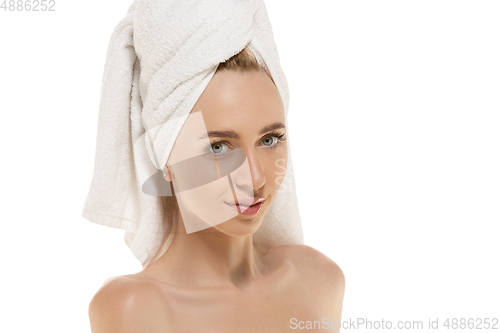 Image of Beauty Day. Woman wearing towel doing her daily skincare routine. Portrait isolated on white studio background