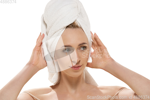 Image of Beauty Day. Woman wearing towel doing her daily skincare routine. Portrait isolated on white studio background