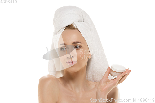 Image of Beauty Day. Woman wearing towel doing her daily skincare routine. Portrait isolated on white studio background