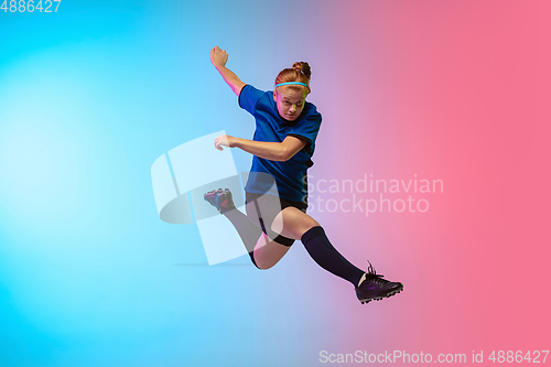 Image of Female soccer, football player training in action isolated on gradient studio background in neon light