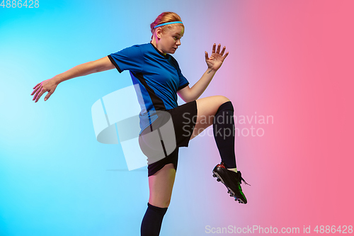 Image of Female soccer, football player training in action isolated on gradient studio background in neon light