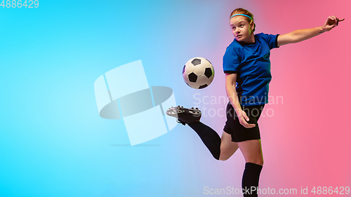 Image of Female soccer, football player training in action isolated on gradient studio background in neon light