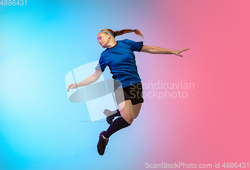 Image of Female soccer, football player training in action isolated on gradient studio background in neon light