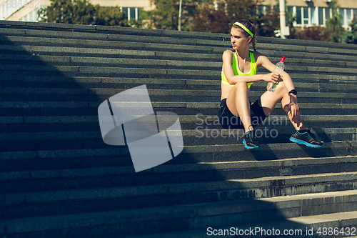 Image of Female runner, athlete training outdoors in summer\'s sunny day.