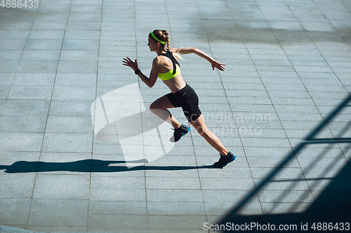 Image of Female runner, athlete training outdoors in summer\'s sunny day.