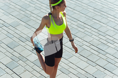 Image of Female runner, athlete training outdoors in summer\'s sunny day.