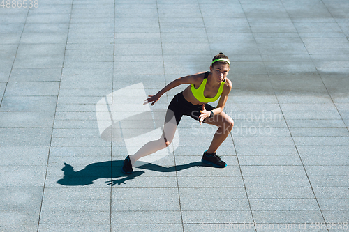 Image of Female runner, athlete training outdoors in summer\'s sunny day.