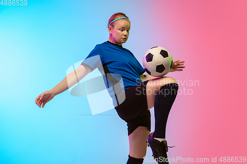 Image of Female soccer, football player training in action isolated on gradient studio background in neon light