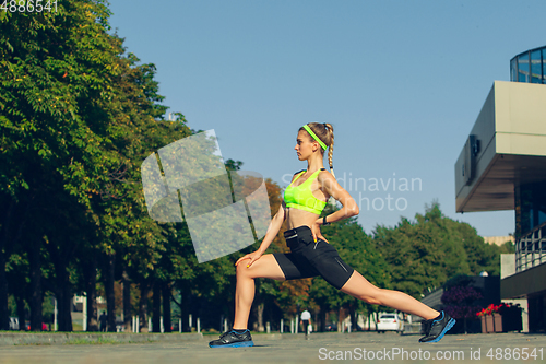 Image of Female runner, athlete training outdoors in summer\'s sunny day.