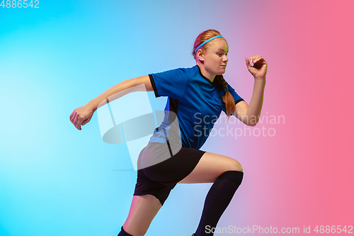 Image of Female soccer, football player training in action isolated on gradient studio background in neon light