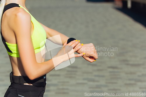 Image of Female runner, athlete training outdoors in summer\'s sunny day.