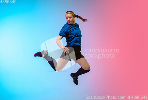 Image of Female soccer, football player training in action isolated on gradient studio background in neon light