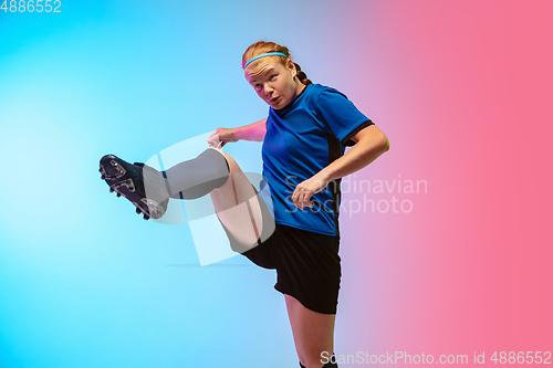 Image of Female soccer, football player training in action isolated on gradient studio background in neon light