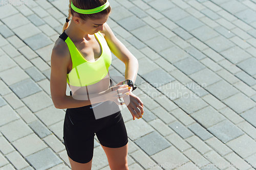 Image of Female runner, athlete training outdoors in summer\'s sunny day.