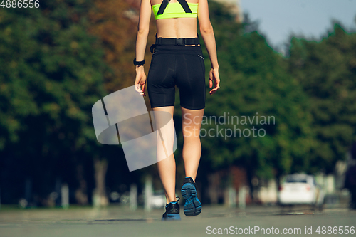 Image of Female runner, athlete training outdoors in summer\'s sunny day.