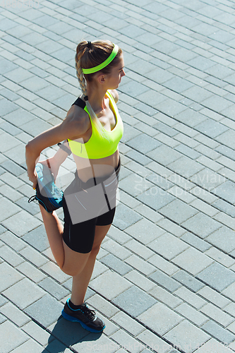 Image of Female runner, athlete training outdoors in summer\'s sunny day.