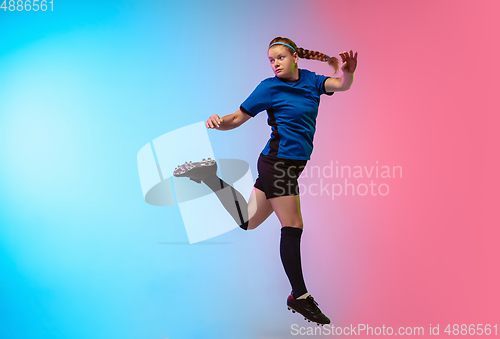 Image of Female soccer, football player training in action isolated on gradient studio background in neon light