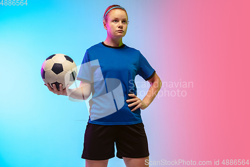 Image of Female soccer, football player training in action isolated on gradient studio background in neon light