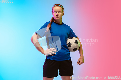 Image of Female soccer, football player training in action isolated on gradient studio background in neon light