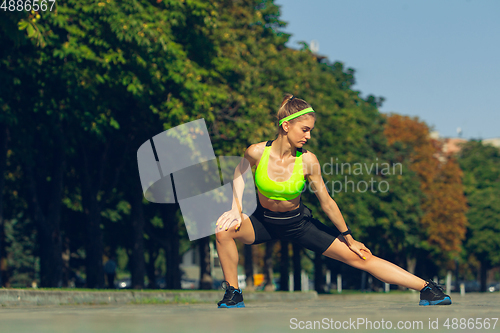 Image of Female runner, athlete training outdoors in summer\'s sunny day.