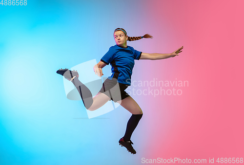 Image of Female soccer, football player training in action isolated on gradient studio background in neon light