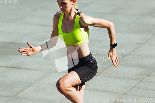 Image of Female runner, athlete training outdoors in summer\'s sunny day.