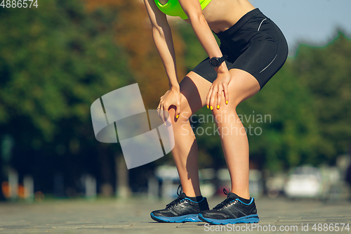 Image of Female runner, athlete training outdoors in summer\'s sunny day.