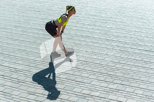 Image of Female runner, athlete training outdoors in summer\'s sunny day.