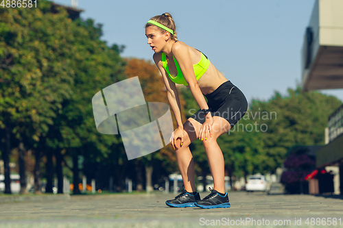 Image of Female runner, athlete training outdoors in summer\'s sunny day.