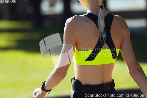 Image of Female runner, athlete training outdoors in summer\'s sunny day.